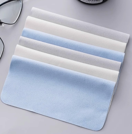 Blue, white and gray microfiber eyeglass cleaning cloths arranged in a stack