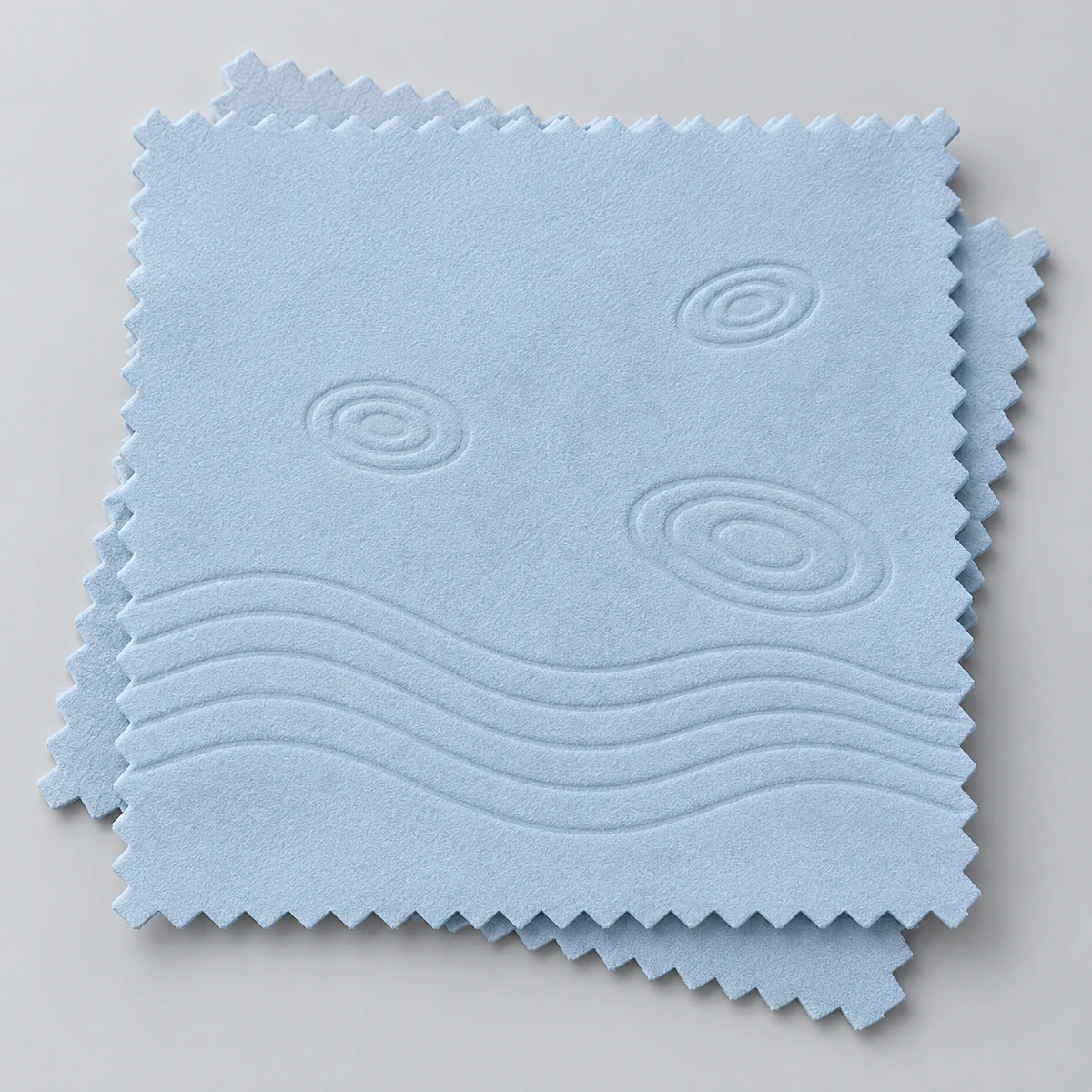 Light blue silver polishing cloths with embossed waves and circular motifs