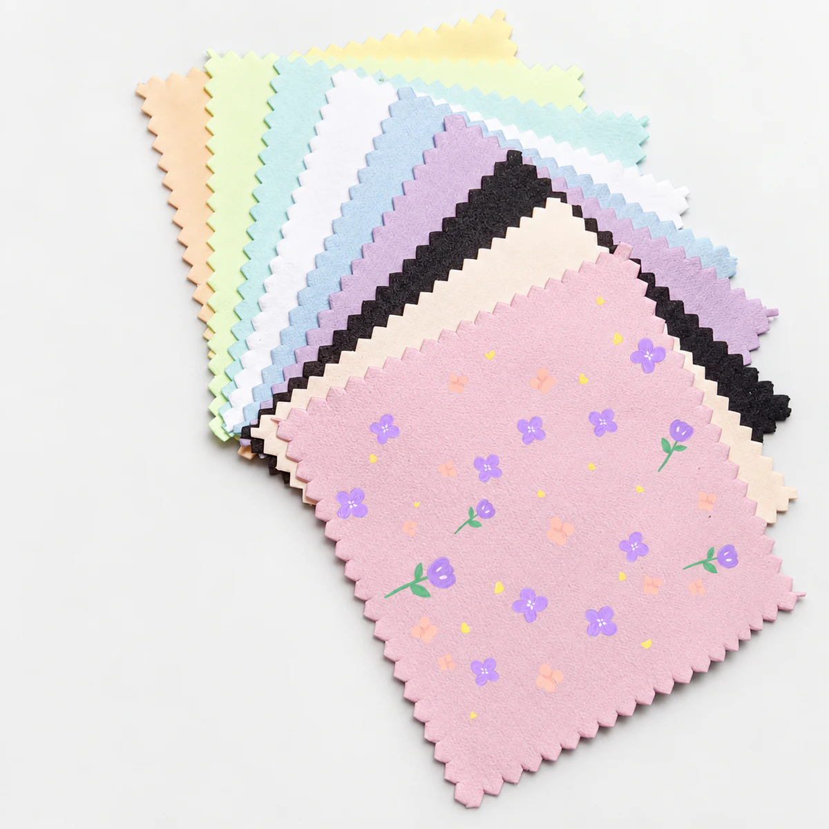 Assorted color silver polishing cloths with a multicolor floral print on the front pink cloth